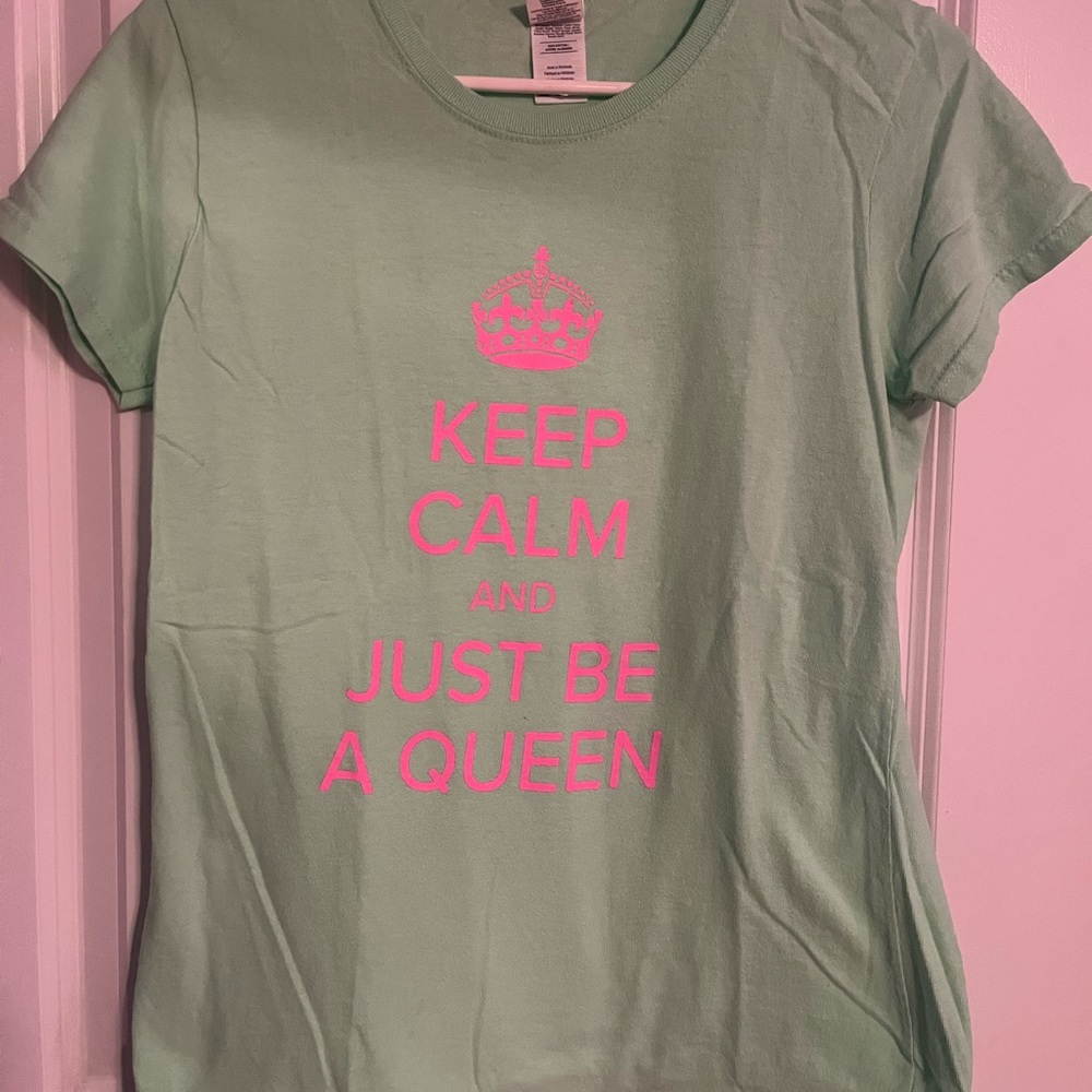 A green and pink tshirt saying Keep Calm and Just Be A Queen shirt.